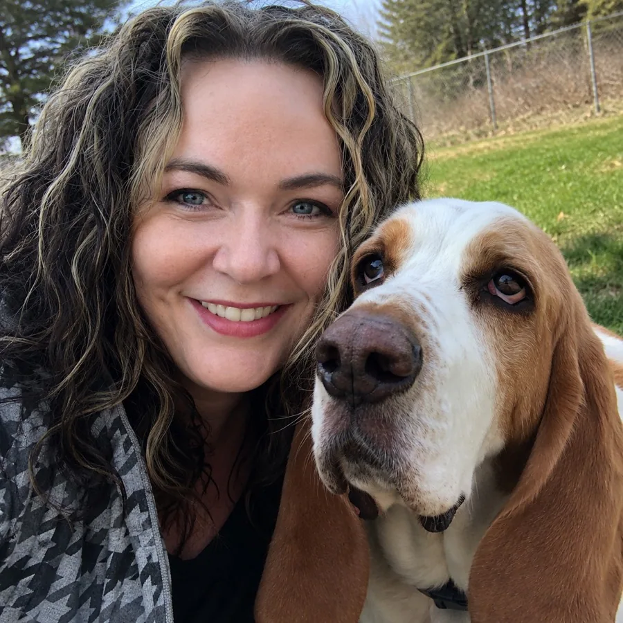 Jollytails co-founder Pamela Smith smiling beside a basset hound
