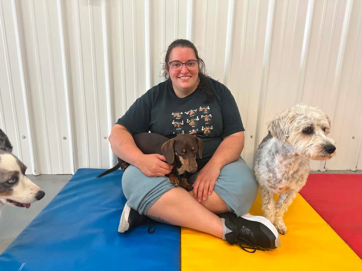 Kayla from the Jollytails Burnside daycare team with three dogs
